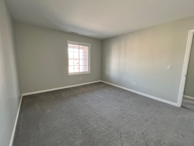 empty room with dark colored carpet