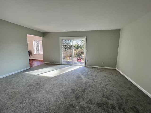 spare room with dark colored carpet