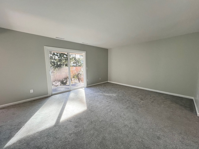 spare room with dark colored carpet