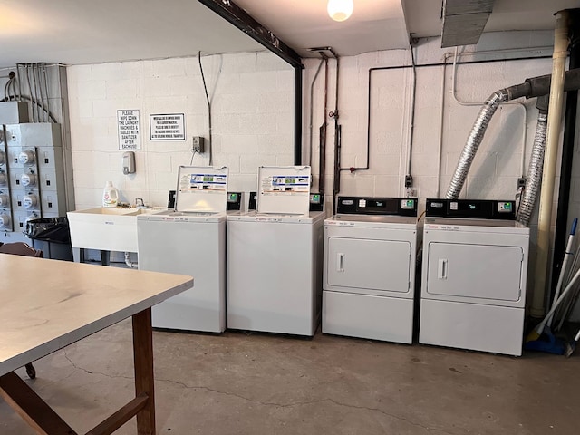 clothes washing area with separate washer and dryer and sink