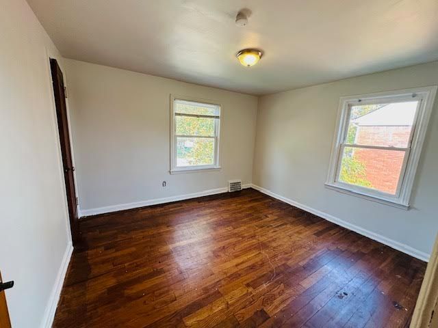 unfurnished room featuring dark hardwood / wood-style flooring