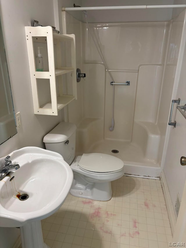 bathroom featuring tile patterned floors, toilet, walk in shower, and sink