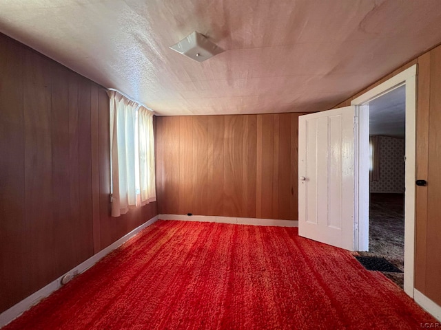 carpeted empty room with wooden walls