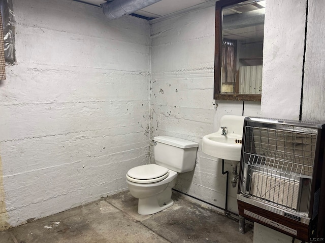 bathroom featuring toilet, concrete flooring, and heating unit