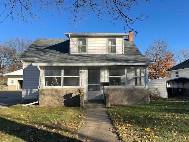 bungalow-style house featuring a front lawn and a carport