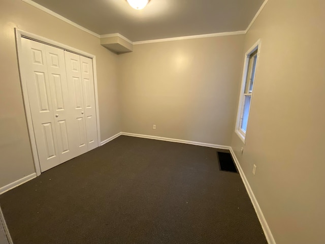 unfurnished bedroom with carpet, crown molding, and a closet