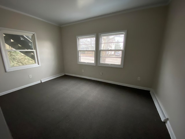 spare room with crown molding and dark colored carpet