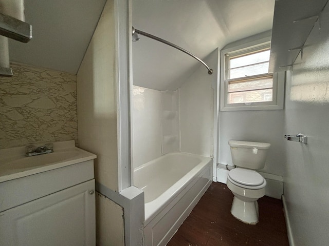 full bathroom featuring hardwood / wood-style floors, vanity,  shower combination, vaulted ceiling, and toilet