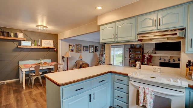 kitchen featuring decorative backsplash, wood-type flooring, kitchen peninsula, and white range