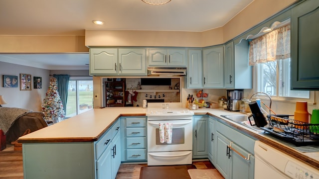 kitchen with kitchen peninsula, light hardwood / wood-style floors, and white appliances