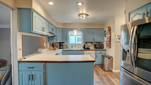 kitchen featuring kitchen peninsula, light wood-type flooring, sink, dishwasher, and stainless steel fridge with ice dispenser