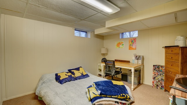 bedroom with carpet, a drop ceiling, and multiple windows