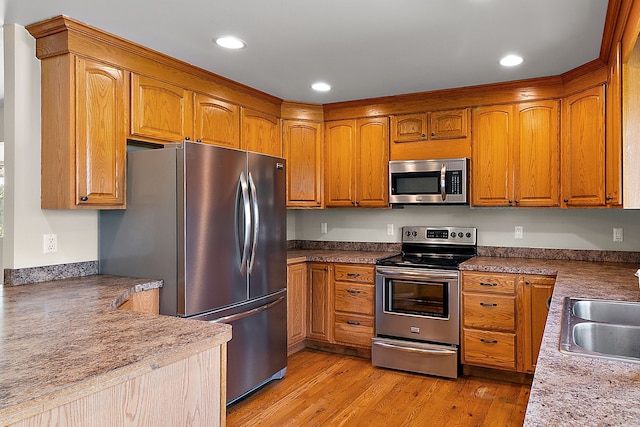 kitchen featuring stainless steel appliances, light hardwood / wood-style floors, and sink