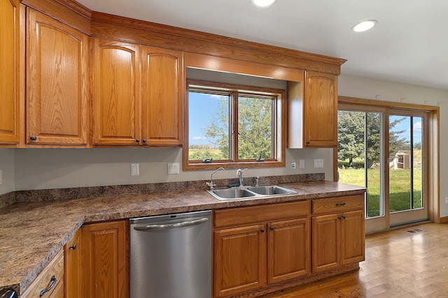 kitchen with stainless steel dishwasher, plenty of natural light, light wood-type flooring, and sink