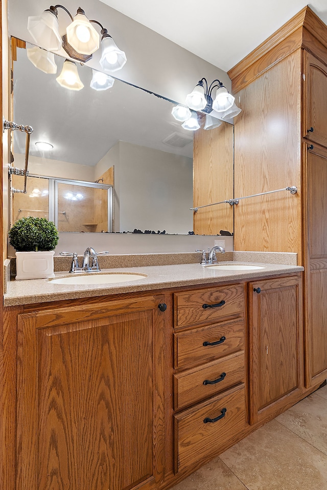 bathroom featuring vanity, an inviting chandelier, tile patterned floors, and an enclosed shower