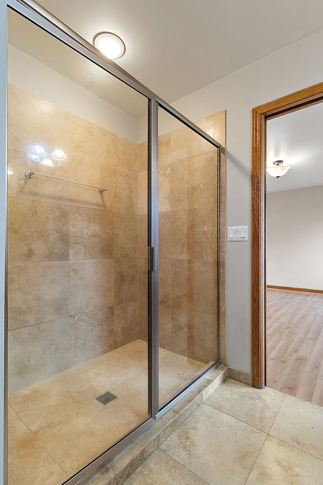 bathroom featuring wood-type flooring and a shower with shower door