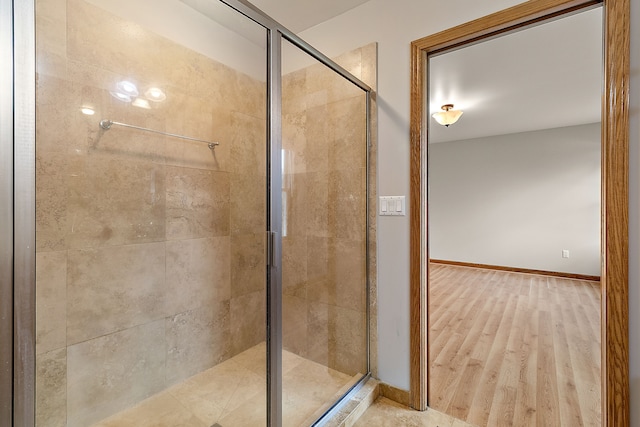 bathroom featuring wood-type flooring and an enclosed shower