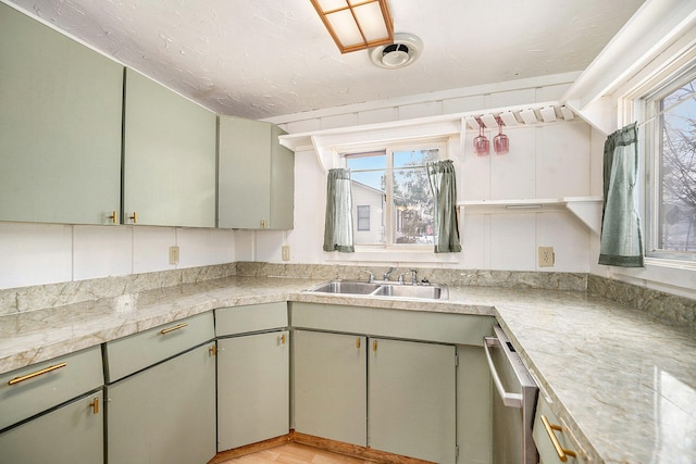 kitchen featuring decorative backsplash, green cabinets, and sink