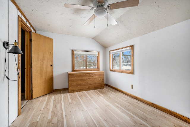 unfurnished bedroom with light wood-type flooring, vaulted ceiling, and ceiling fan