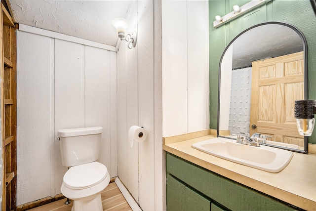 bathroom with hardwood / wood-style floors, vanity, and toilet