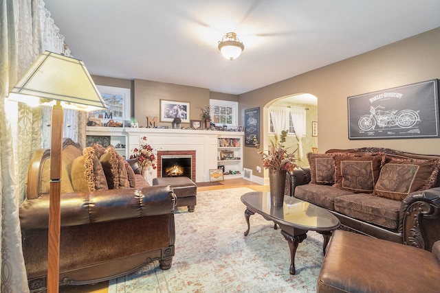 living room with hardwood / wood-style floors and a brick fireplace