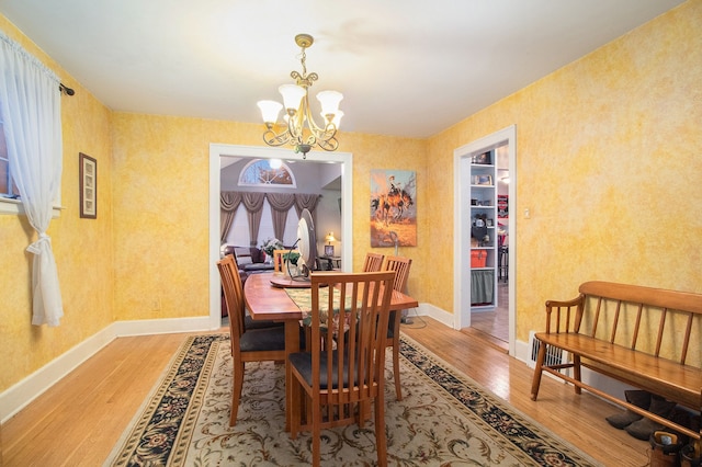 dining space with hardwood / wood-style flooring and a chandelier