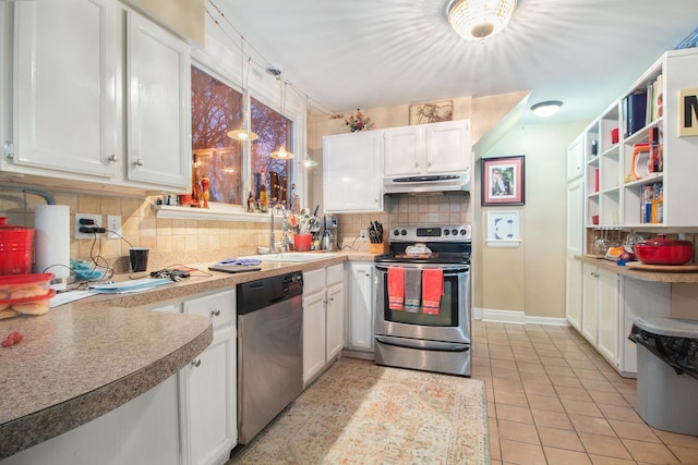 kitchen featuring light tile patterned flooring, decorative light fixtures, decorative backsplash, white cabinets, and appliances with stainless steel finishes