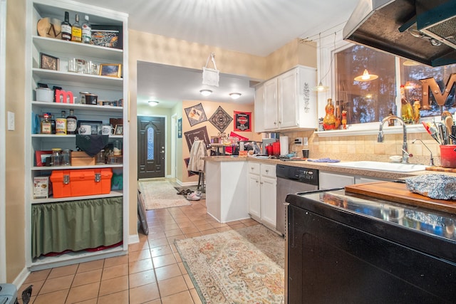 kitchen featuring sink, light tile patterned floors, stainless steel dishwasher, backsplash, and white cabinets