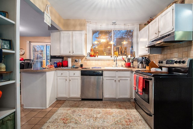 kitchen with white cabinetry, sink, backsplash, light tile patterned floors, and appliances with stainless steel finishes