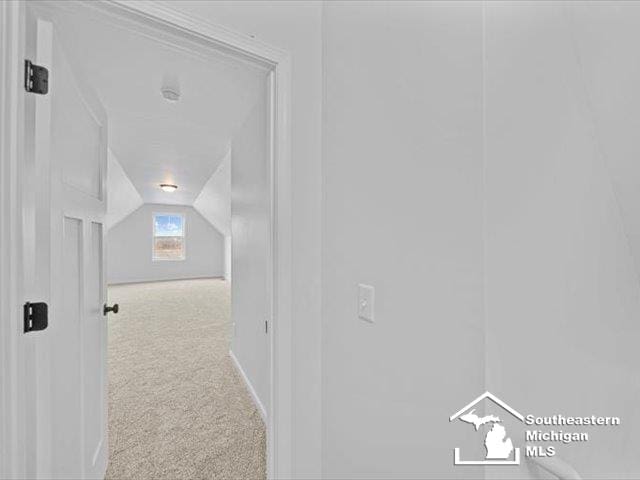 hall featuring carpet floors and lofted ceiling