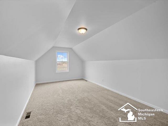 bonus room featuring carpet and vaulted ceiling