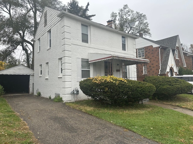 view of front facade with a garage, a front lawn, and an outdoor structure