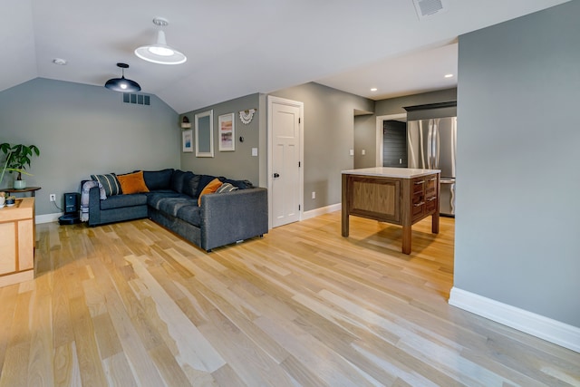 living room with light hardwood / wood-style flooring and vaulted ceiling