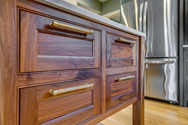 interior details with stainless steel refrigerator and light wood-type flooring