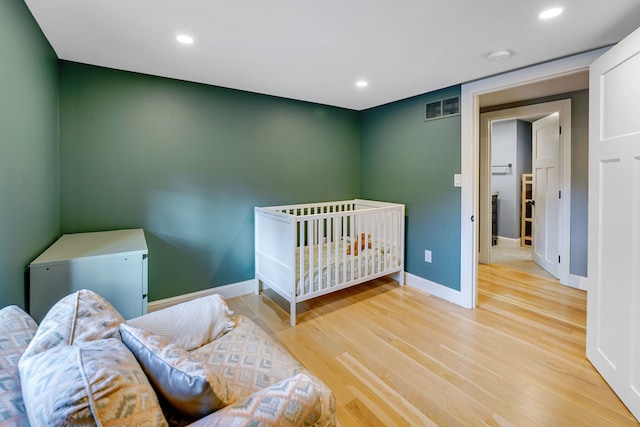 bedroom with white fridge and light hardwood / wood-style flooring