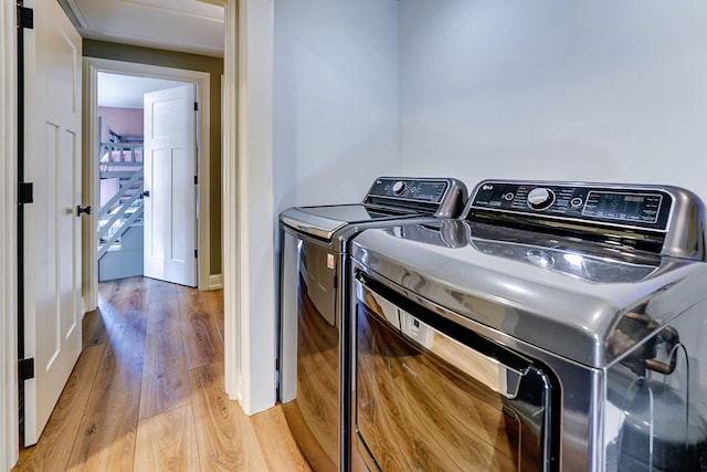 clothes washing area featuring wood-type flooring and independent washer and dryer