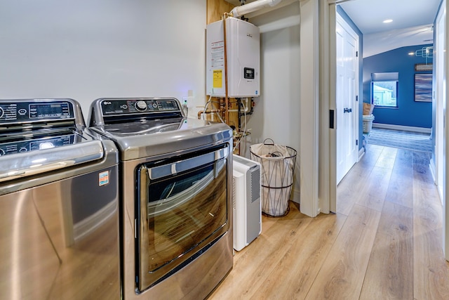 laundry room featuring washer and clothes dryer, tankless water heater, and light wood-type flooring