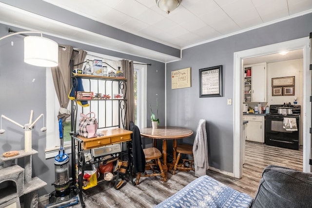 dining area with crown molding and hardwood / wood-style floors