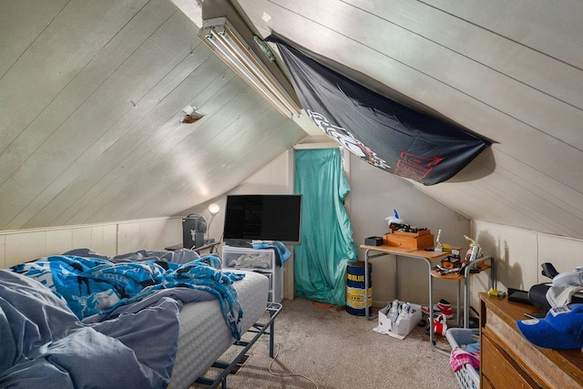 bedroom with carpet flooring, wood walls, and vaulted ceiling