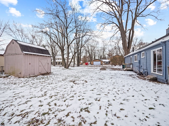 yard covered in snow with a storage unit