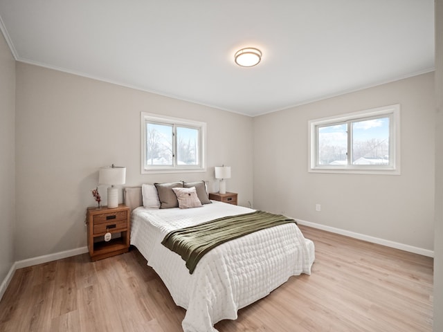 bedroom with crown molding and light wood-type flooring