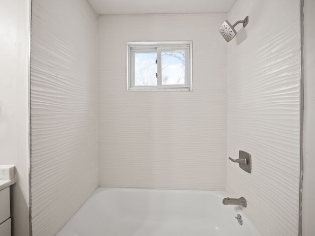 bathroom with tiled shower / bath combo and vanity