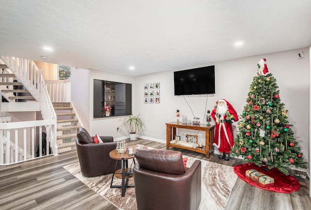 living room with recessed lighting, stairs, baseboards, and wood finished floors