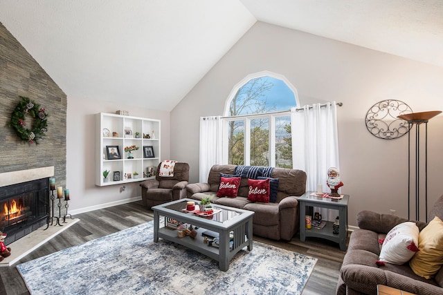 living area with a fireplace, wood finished floors, baseboards, and high vaulted ceiling