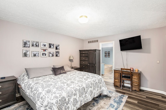 bedroom featuring dark wood finished floors, baseboards, visible vents, and a textured ceiling