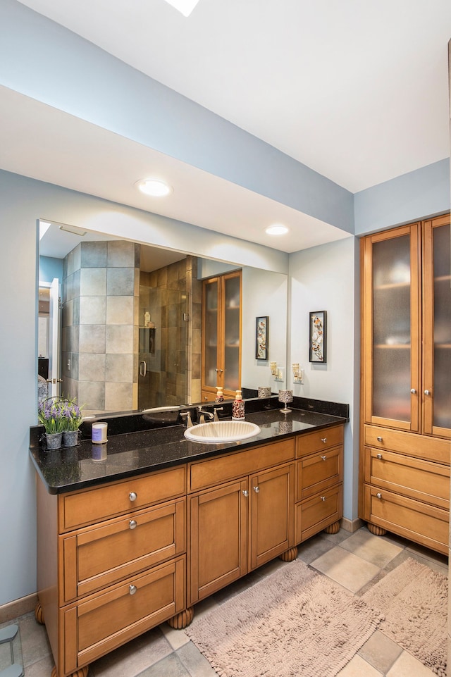 bathroom with vanity, a shower stall, recessed lighting, and baseboards