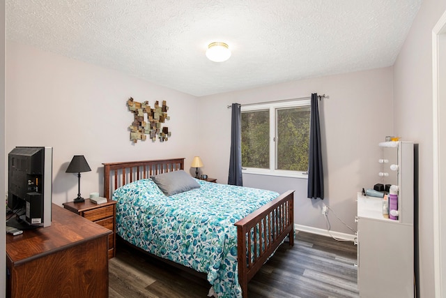 bedroom featuring wood finished floors, baseboards, and a textured ceiling