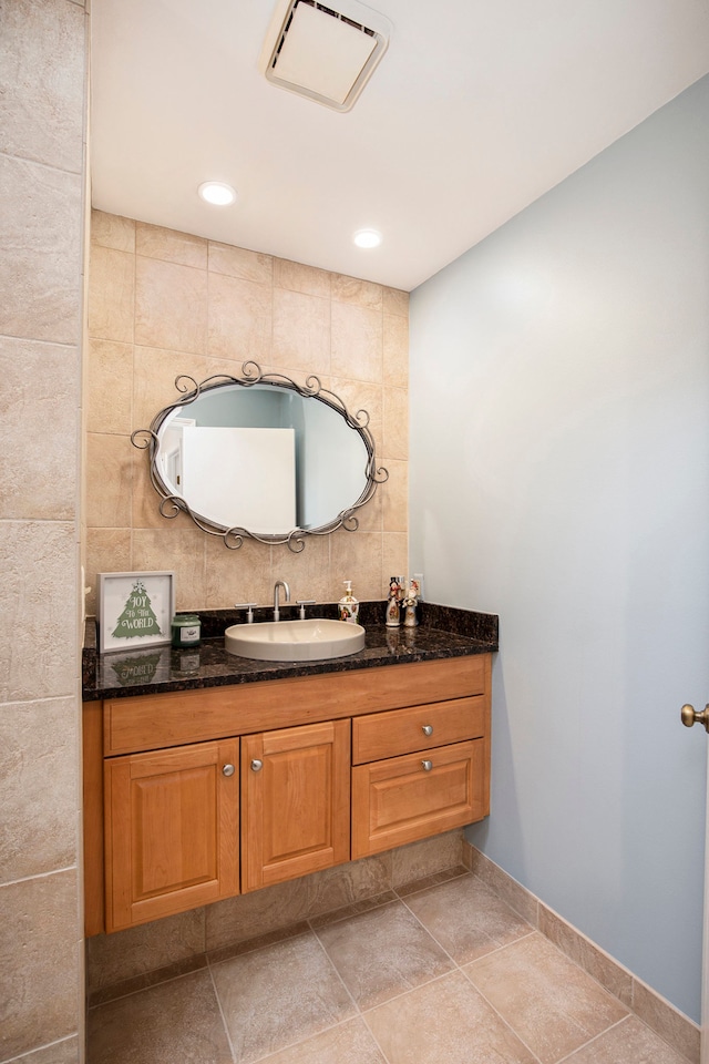 bathroom with tasteful backsplash, visible vents, tile patterned flooring, tile walls, and vanity