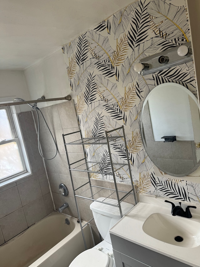 full bathroom with vanity, tiled shower / bath combo, and toilet