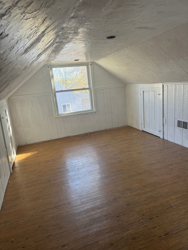 bonus room with wood-type flooring and lofted ceiling